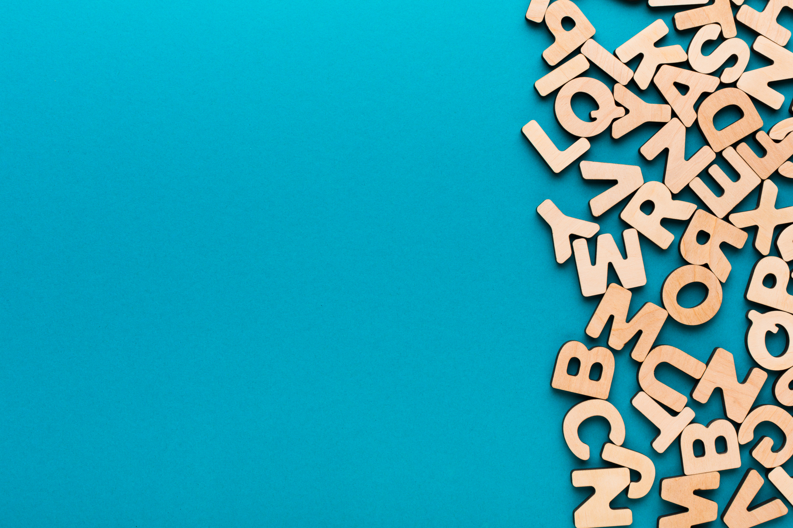 Wooden letters scattered on a blue background.